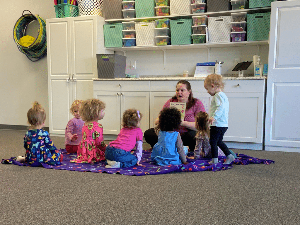 Teacher reads to a circle of children during Kindermusik storytime at Melody Magic Music Studio
